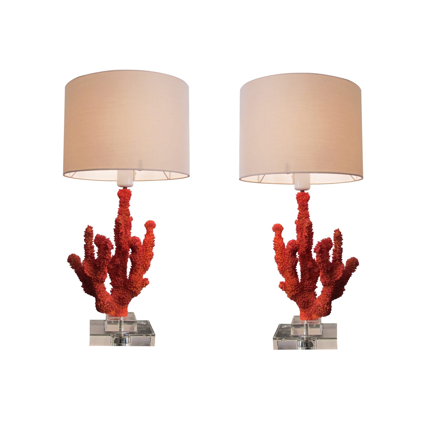 A pair of resin red coral table lamps on a glass base, mid century